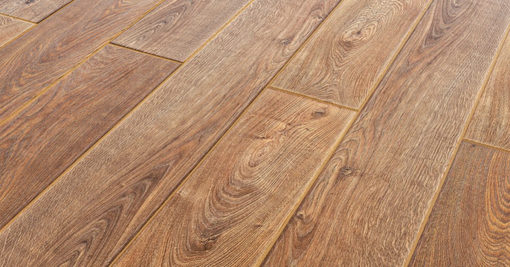 Light brown hardwood flooring installed in a brightly lit room. The wooden planks are wide and long.